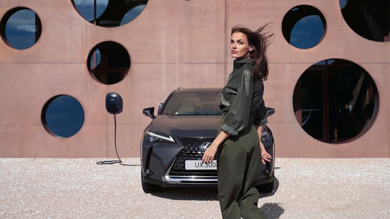 A person stood next to a Lexus UX 300e