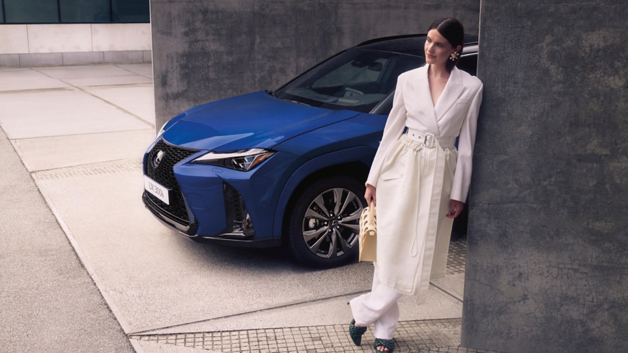 A person stood next to a blue Lexus UX