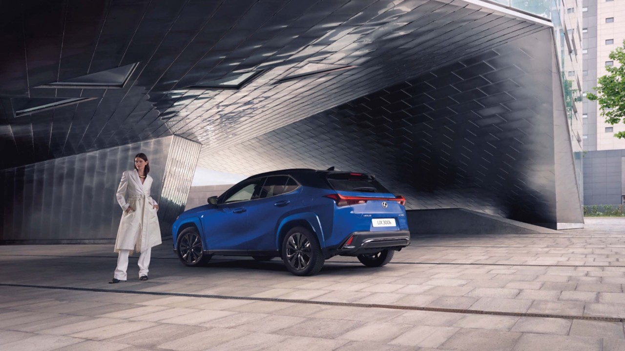 A person stood next to a blue Lexus UX